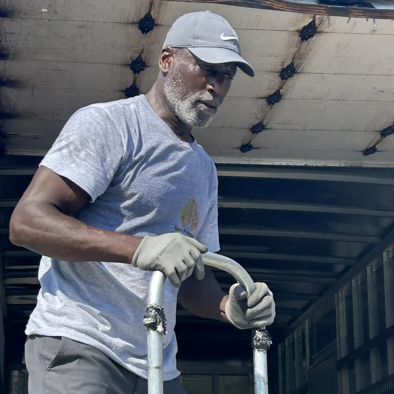 Crew member with a hand truck in a box truck