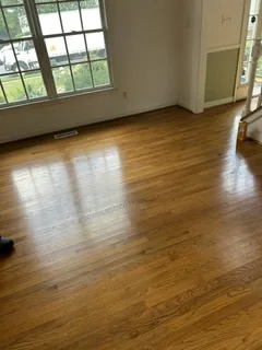 Empty room with polished hardwood floors after a cleanout