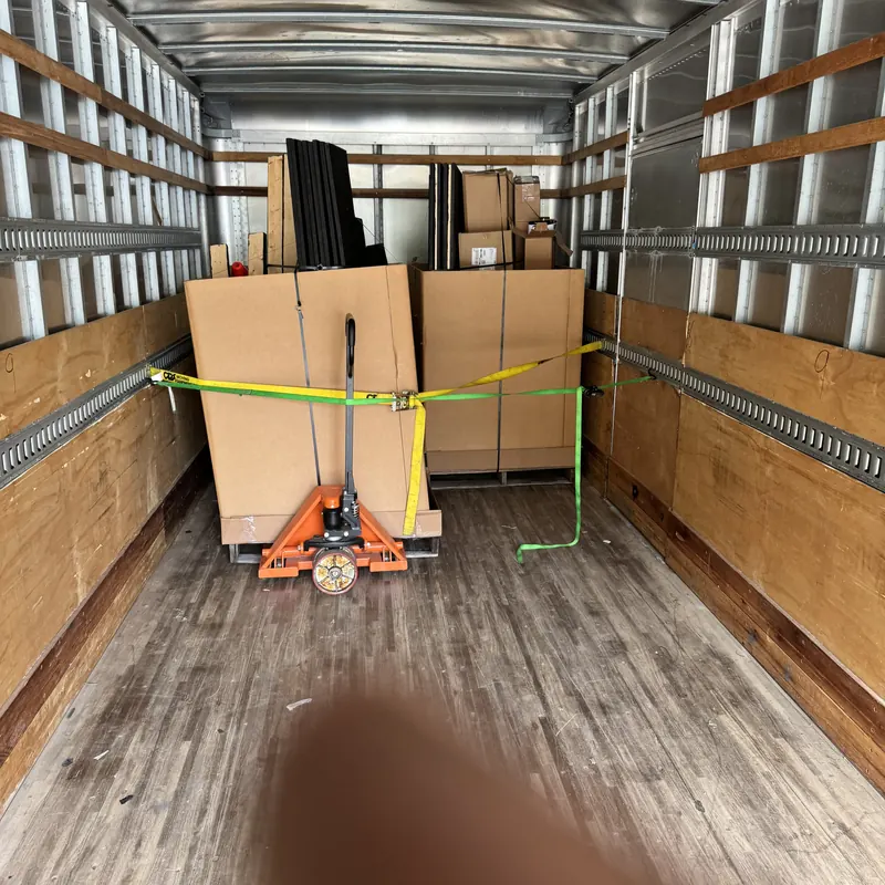 Freight pallets secured with ratchet straps in a box truck