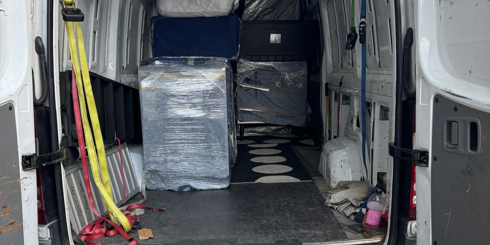 Wrapped furniture loaded in a cargo van with a loading ramp
